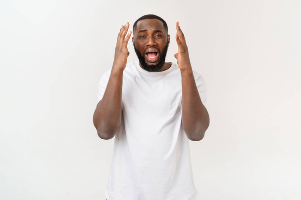 Portret van geschokte jonge Afro-Amerikaanse man het dragen van witte lege T-shirt te kijken naar de camera in verrassing, verbijsterd met een aantal ongelooflijke verhaal. - Foto, afbeelding