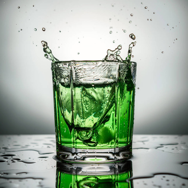 The splashes from the falling ice in green cocktail - Φωτογραφία, εικόνα