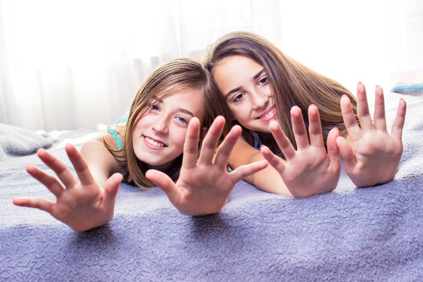 Two cute teenage girls having fun with nail care. Girls, friends activity - Foto, Imagen
