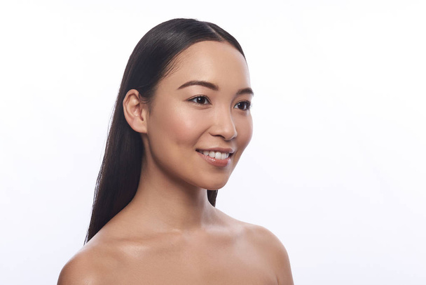 Bare shouldered Asian woman looking away and smiling - Φωτογραφία, εικόνα