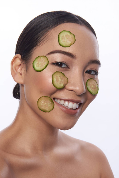 Bare shoulders Asian woman with cucumber mask on her face - Фото, зображення
