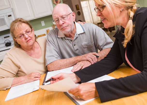 Starší dospělí manželé jdou přes dokumenty v jejich domovech s podpisem agenta při podepisování. - Fotografie, Obrázek