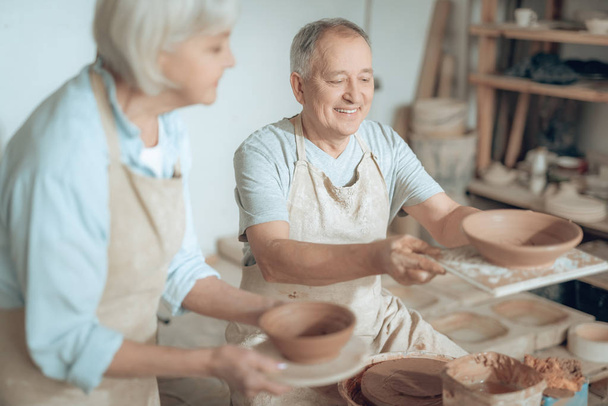 High angle of two clay masters showing their works in potters studio - Foto, Imagem