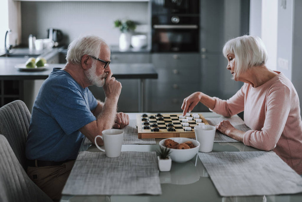 Elder pensioner couple playing checks at home - Φωτογραφία, εικόνα