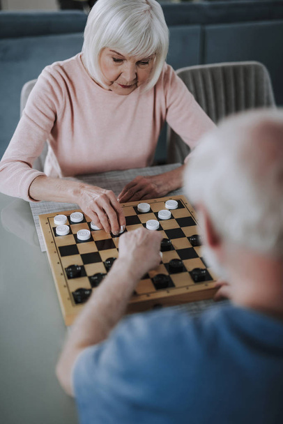 Älteres Paar spielt Schecks sitzend auf Tisch - Foto, Bild