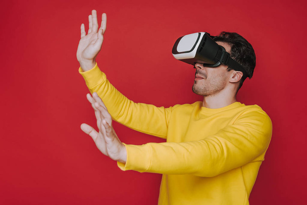 Widok z boku kaukaski człowiek dotykając czegoś podczas sytuowania w wirtualnej rzeczywistości - Zdjęcie, obraz