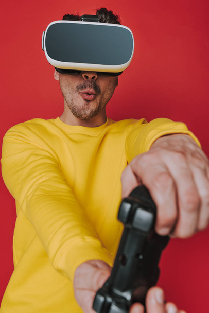 Low angle of cheerful man playing game using virtual reality headset - Foto, Bild