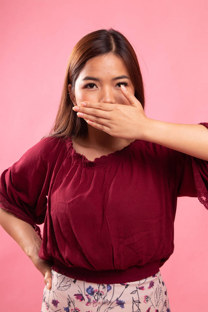 Молодая азиатка закрывает рот рукой
. - Фото, изображение