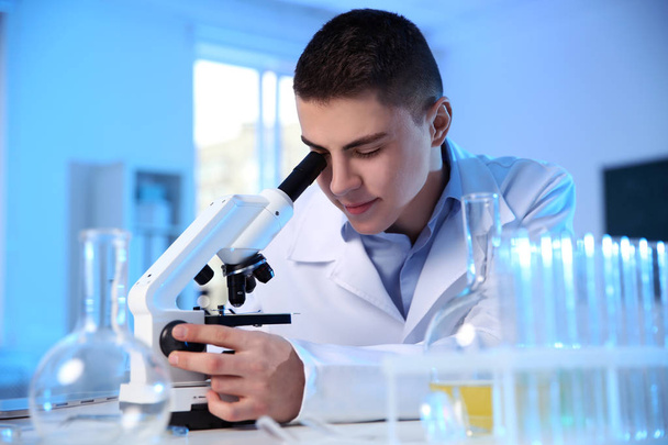 Male scientist using modern microscope in chemistry laboratory - Fotó, kép