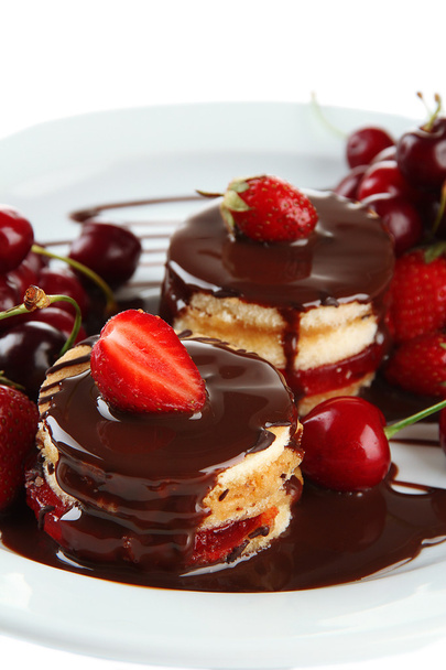 Tasty biscuit cakes with chocolate and berries on plate, close up - Foto, immagini