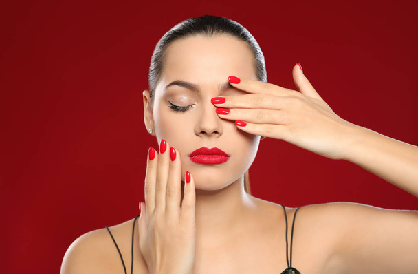 Portrait of beautiful young woman with bright manicure on color background. Nail polish trends - Фото, зображення