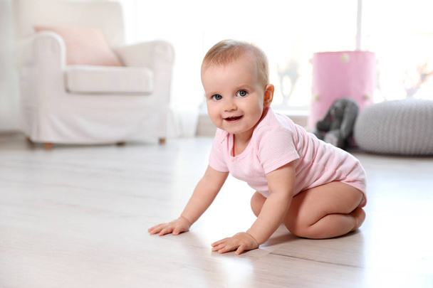 Cute baby girl sitting on floor in room - Φωτογραφία, εικόνα