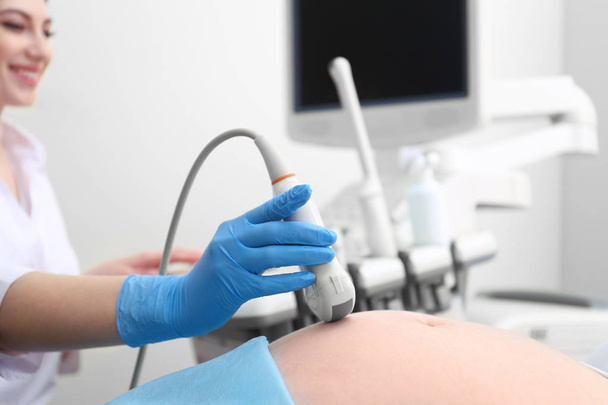 Pregnant woman undergoing ultrasound scan in clinic, closeup - Foto, imagen