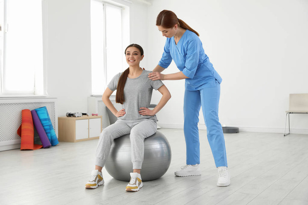 Professional physiotherapist working with female patient in rehabilitation center - Zdjęcie, obraz