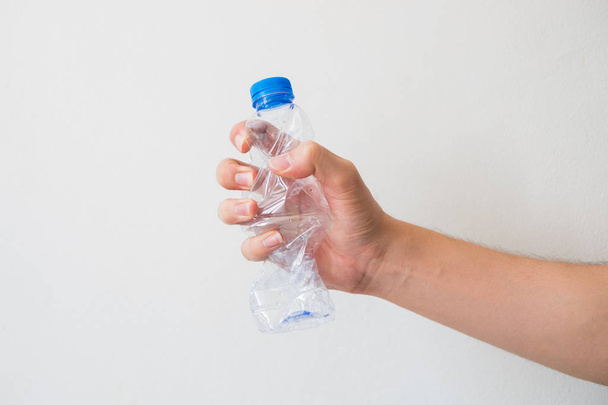 Hand holding a recyclable plastic bottles on white background.  - Photo, Image