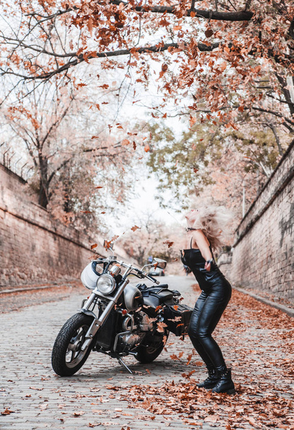 Gyönyörű motoros nő pózol a motorkerékpár a szabadban. - Fotó, kép
