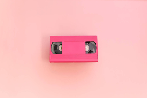 Pink videocassette tape op roze achtergrond. - Foto, afbeelding