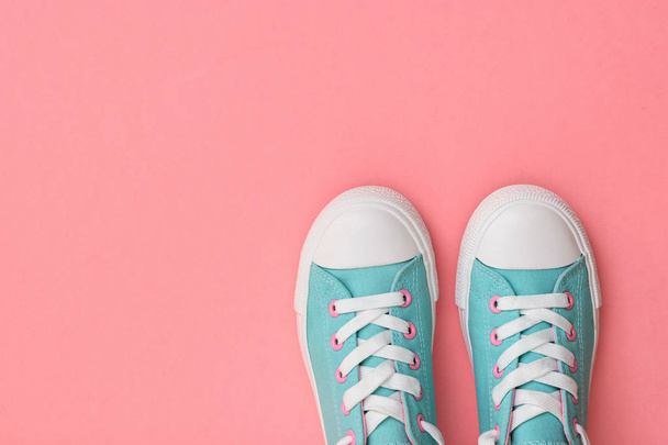 Un par de zapatillas de color turquesa sobre un fondo rosa. Tendencia de color 2019. Estilo deportivo. Puesta plana
. - Foto, imagen