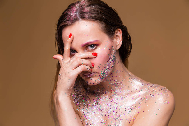 Mujer modelo de moda con maquillaje de brillo de moda mirada a través de los dedos
 - Foto, Imagen