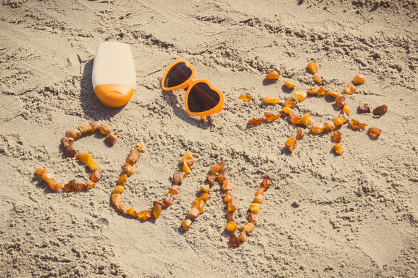 Vintage photo, Word and shape of sun, sunglasses with sun lotion on sand at beach - Fotoğraf, Görsel