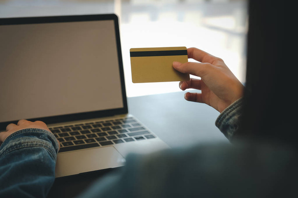 женщина держит кредитную карту с помощью компьютера для покупок в Интернете
 - Фото, изображение