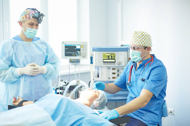 tの間に手術テーブルの上の患者を取り巻く数人の医者 - 写真・画像