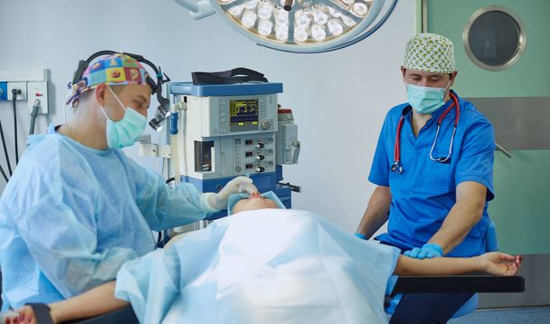 Varios médicos que rodean al paciente en la mesa de operaciones durante t
 - Foto, Imagen