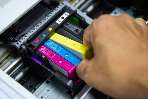 Los técnicos están instalando el cartucho de inyección de tinta de la impresora a color
 - Foto, imagen
