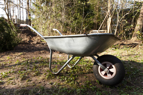 Wheelbarrow standing in a clearing facing the right - Photo, Image