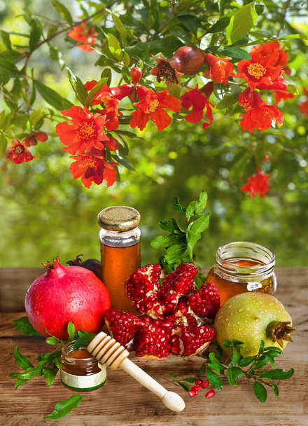 Ρόδια ώριμα με μέλι και μέλι για Rosh Hashanah - εβραϊκή γιορτή. - Φωτογραφία, εικόνα