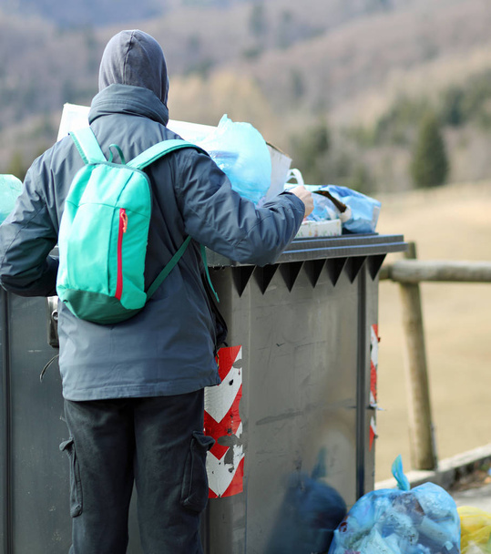 poor boy looks for something to eat in the rubbish bin - 写真・画像