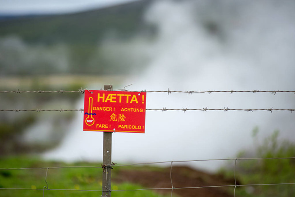Gefahrenschild in verschiedenen Sprachen in der Nähe einer heißen Quelle in Island - Foto, Bild