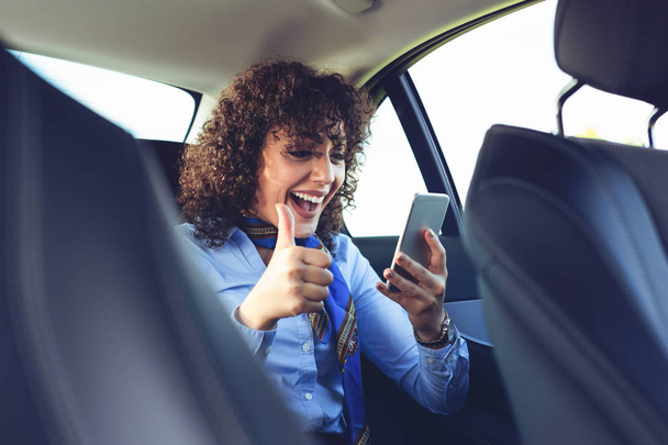 Beautiful young woman smile and use mobile phone inside the car while travel.  - Fotoğraf, Görsel