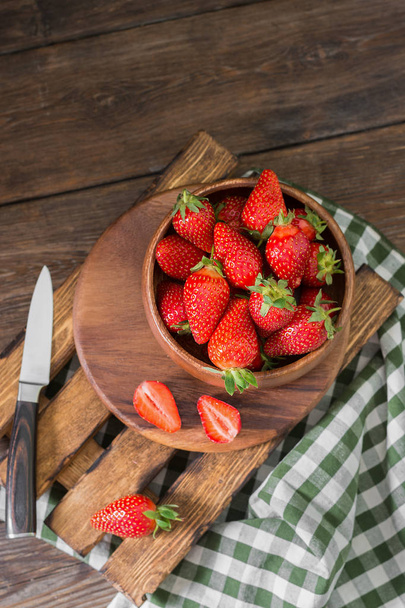 Strawberry in wooden bowl on wooden background. Rustic style - Fotografie, Obrázek