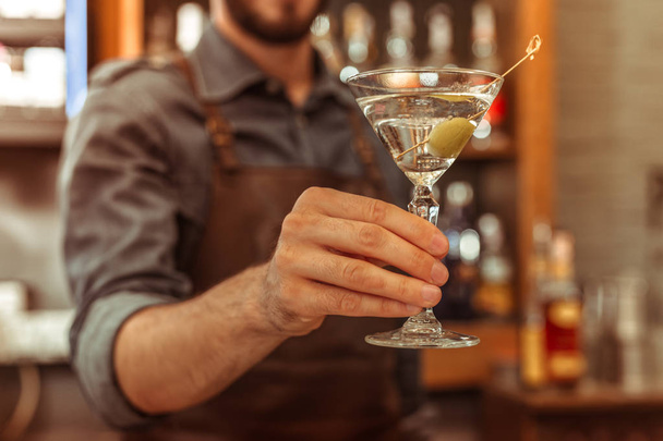 Close-up photo of bar worker holding a martini cocktail - Фото, изображение