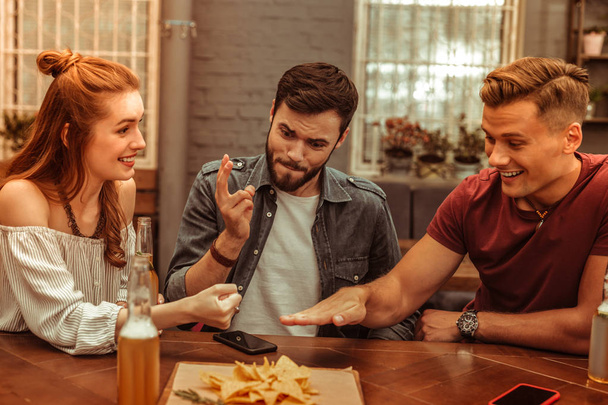 Three friends playing games at the bar while having drinks - Valokuva, kuva