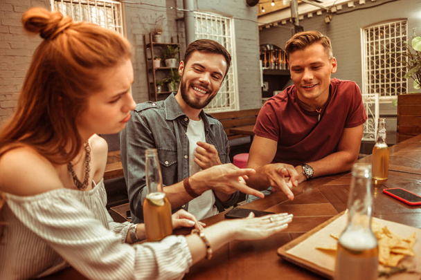 Three nice-appealing good-looking young-adult friends playing rock-paper-scissors game - Fotoğraf, Görsel