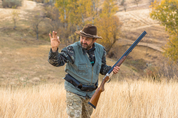 Chasseur avec un chapeau et une arme à feu à la recherche de proies dans la steppe, Vise la proie
 - Photo, image