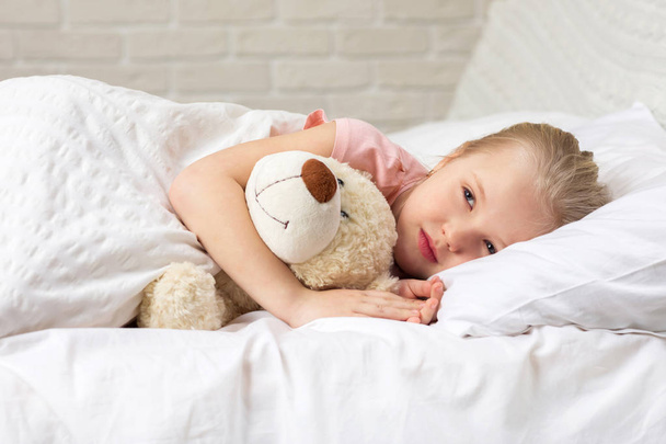 Cute little child girl sleeping with teddy bear - Fotografie, Obrázek