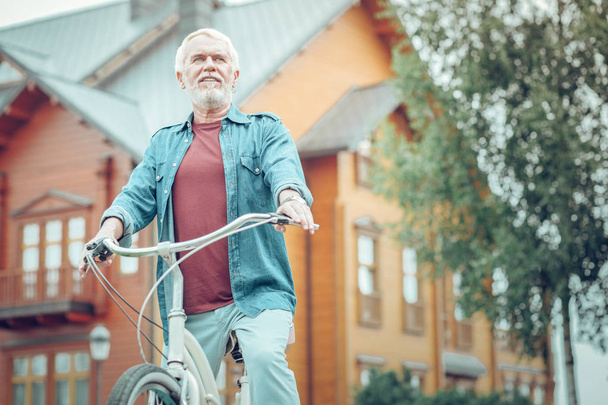 Nice pleasant bearded man riding a bicycle - Foto, Imagen