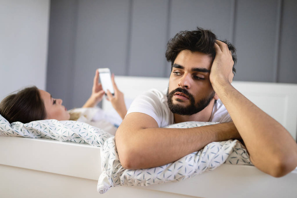 Unhappy upset couple ignoring each other using mobile phone - Photo, Image
