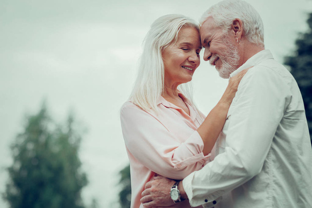 Pleasant nice aged couple hugging each other - Photo, Image