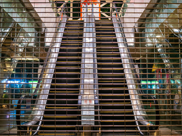 Geschlossene Rolltreppen durch einen verschlossenen Eingang einer Abteilung gesehen - Foto, Bild