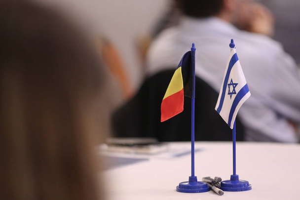Auf einem Tisch liegen rumänische und israel-Flaggen nebeneinander. Iserlohn - Foto, Bild
