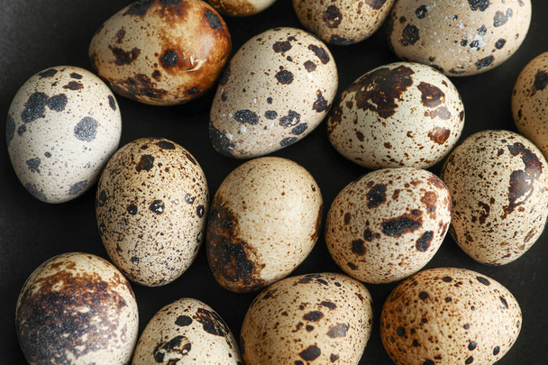 Many quail eggs on black background, closeup - Zdjęcie, obraz