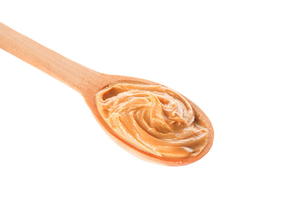 Сливочное арахисовое масло в деревянной ложке изолированы на белой спинке
 - Фото, изображение