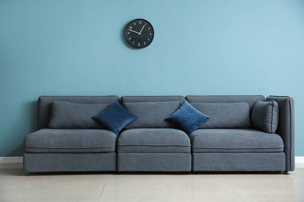 Άνετο καναπέ κοντά σε χρώμα τοίχου - Φωτογραφία, εικόνα