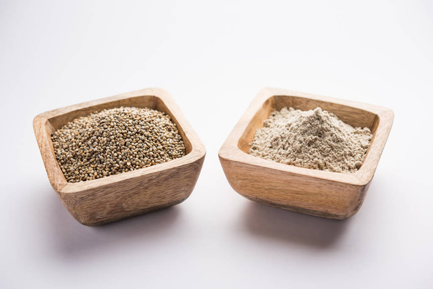 Bajra (mijo perla) / granos de sorgo con su harina o polvo en un tazón, enfoque selectivo
 - Foto, Imagen