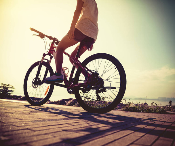 woman riding bike no handed on sunny seaside  - Zdjęcie, obraz