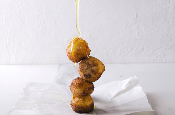 Pouring honey on the donut holes cooked with cheese.Delicious deep fried dough balls with cheese and honey - Photo, Image